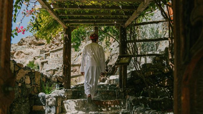 Climbing stairs to The Suwgra Omani man walking up the stairs