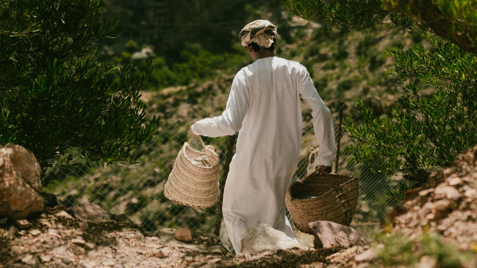 Boy carrying Omani food for guests An Omani boy carrying food in the mountain to The Suwgra Inn for guests.