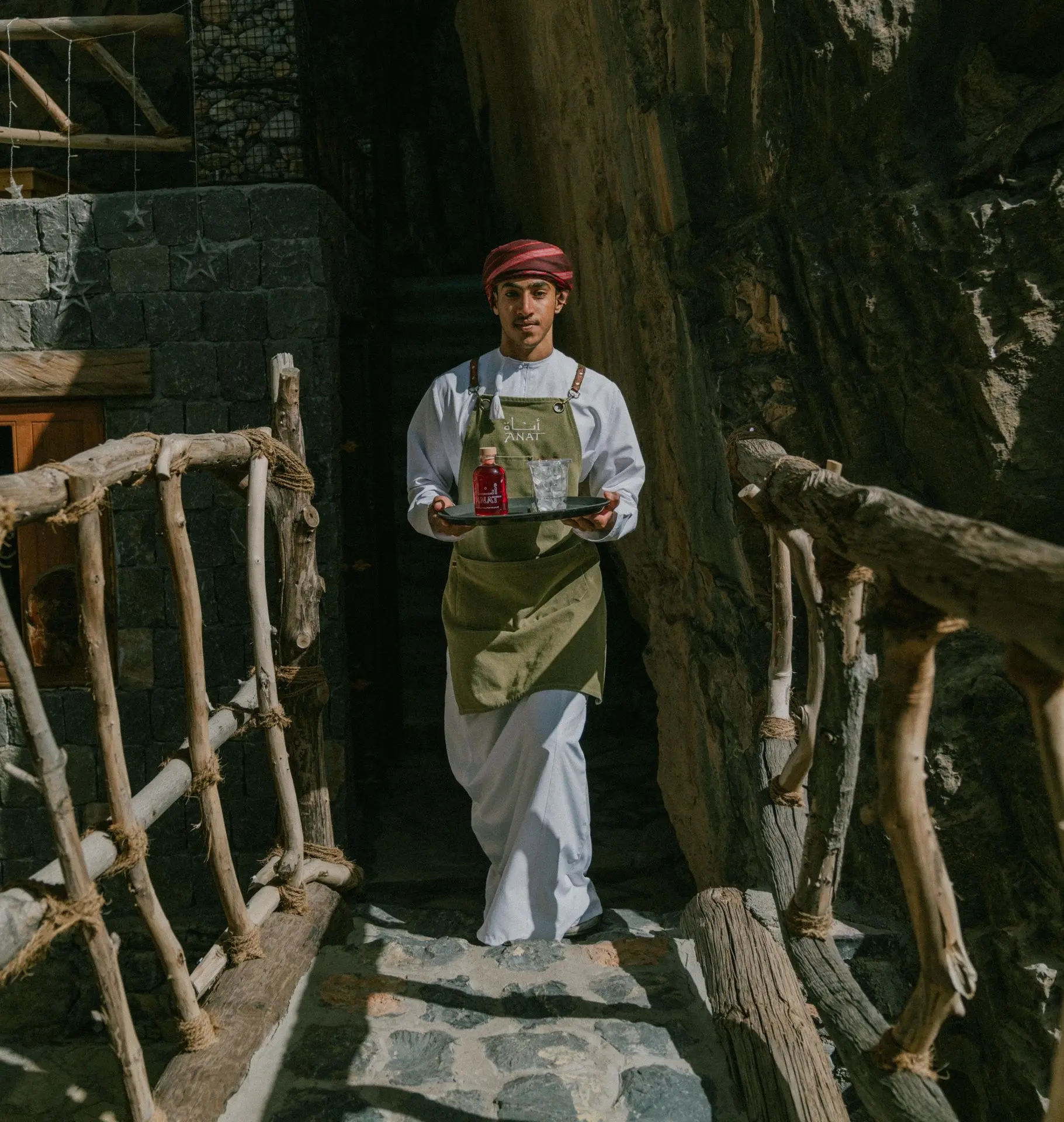 Omani barista carriyng a tray Omani barista carrying a tray of Pomegranate iced tea to cafe guests