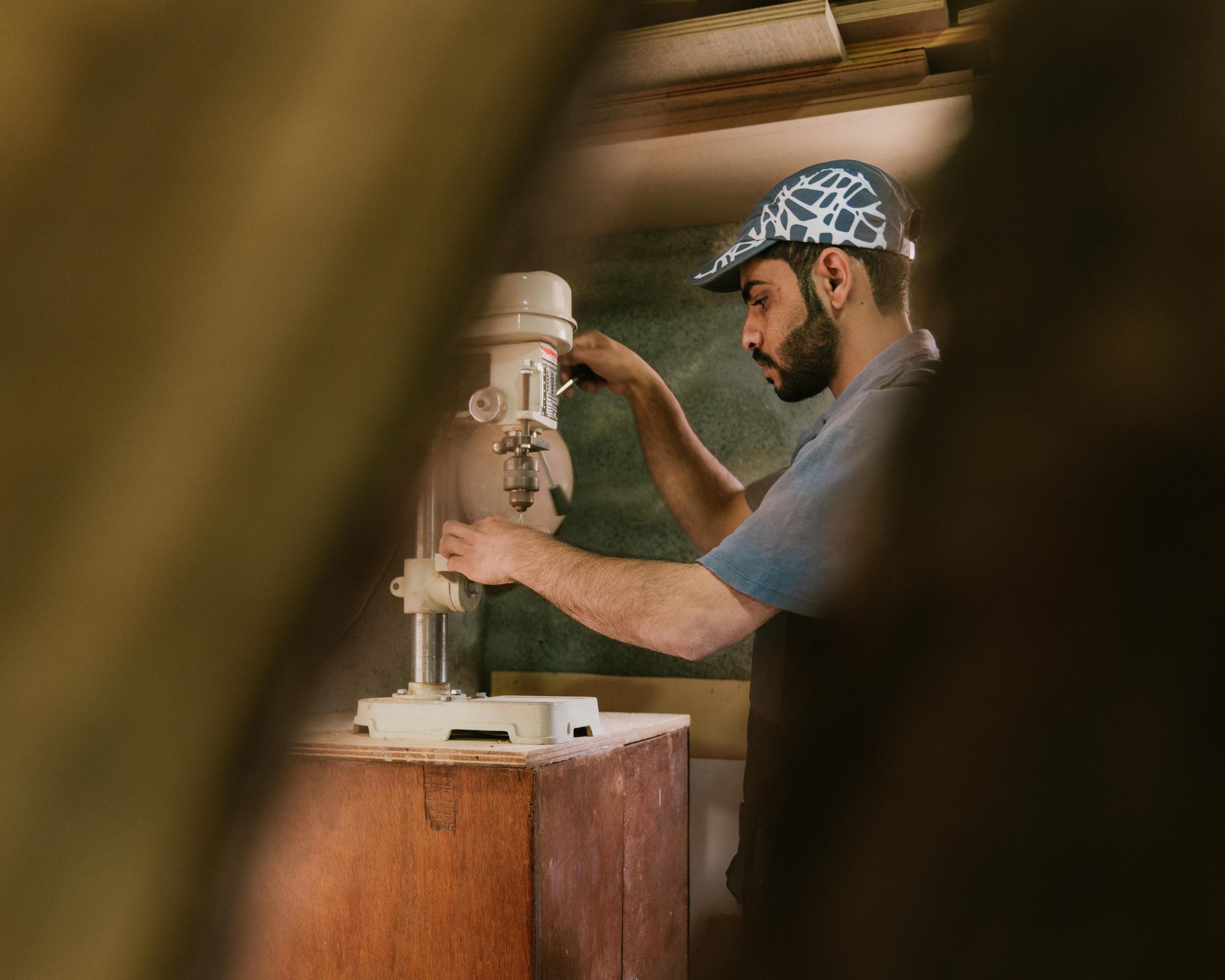 Omani man in wood workshop carving with a traditional machine 